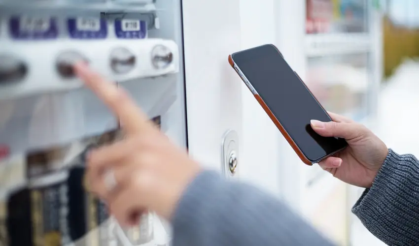 Woman use of soft drink vending system paying by cellphone