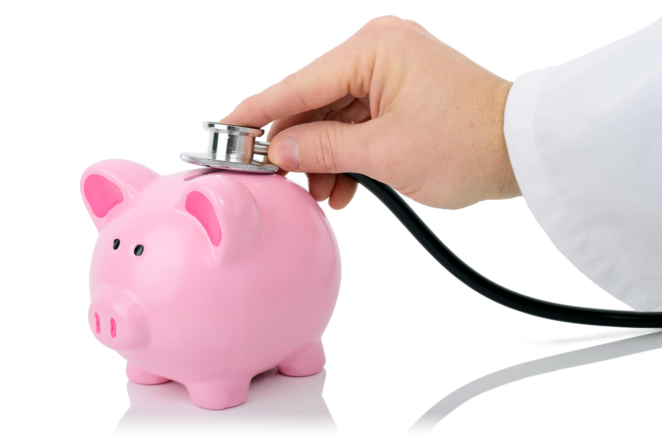 person holding a stethoscope to a piggy bank