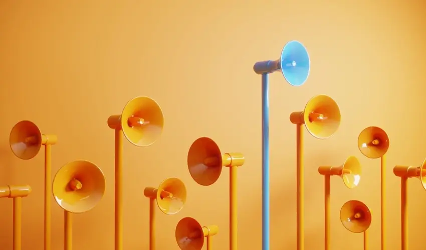 Group of orange megaphones with one tall blue megaphone standing out against an orange background.