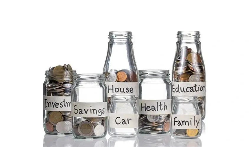 Glass jars filled with coins labeled Investment, Savings, Car, House, Health, Family, and Education.