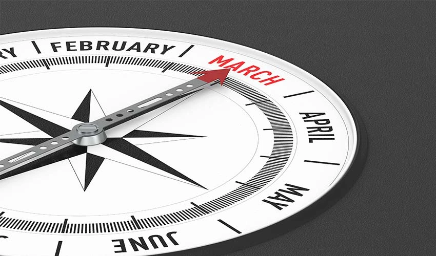 Compass with the months around the outside with the arrow pointing at March