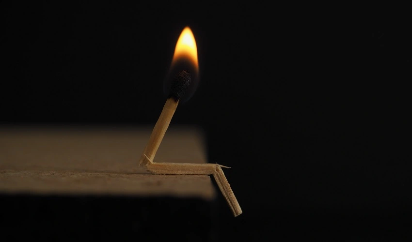 A lighted match appearing to be sitting on a ledge