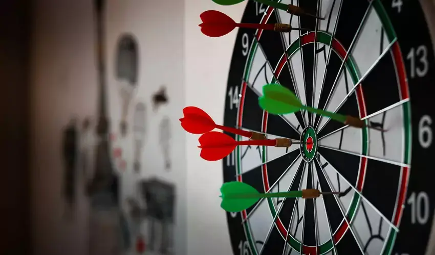 Dart board with green and red darts 