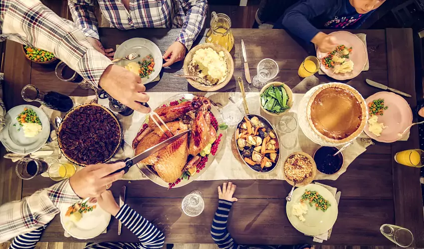 Family sitting at table with Thanksgiving feast