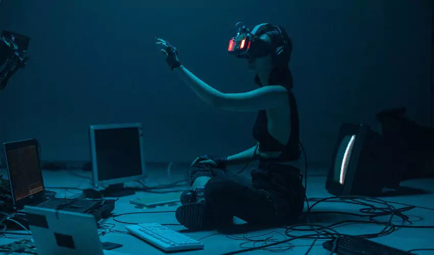 Girl in blue lit room with vr and computers