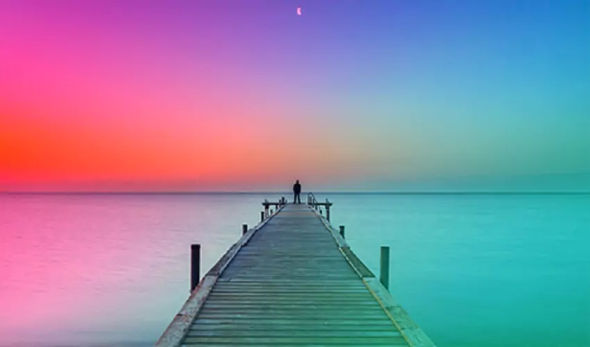 Man standing at the end of a pier with a multi color overlay