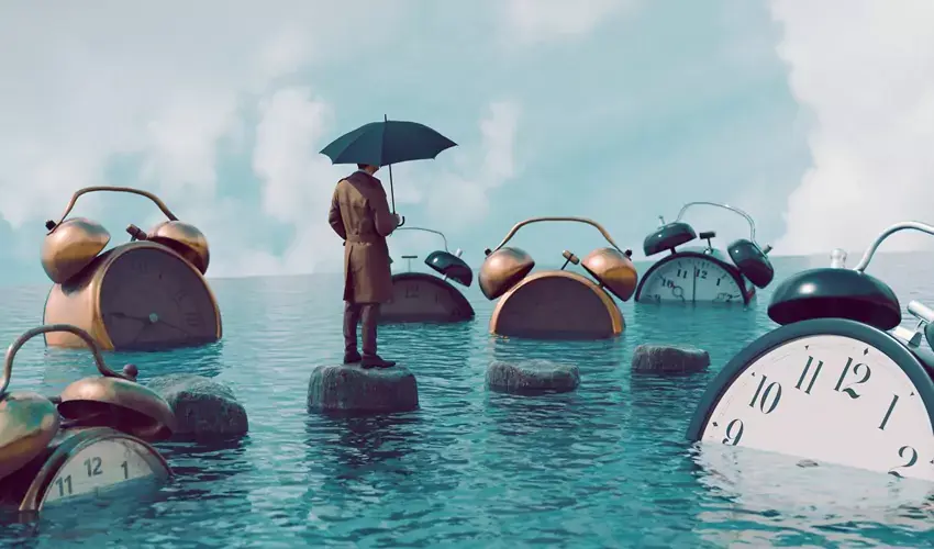 Man standing on rock in water surrounded by clocks