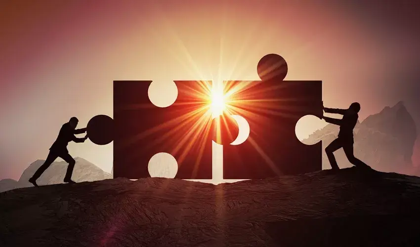 Two people pushing puzzle pieces