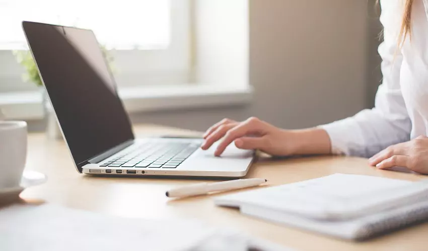 Woman at computer with notepad