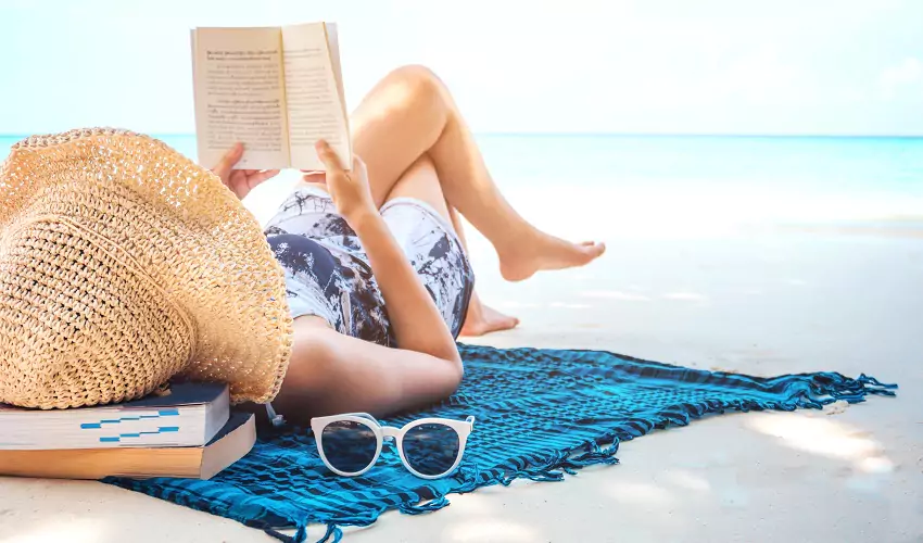 Woman lying on beach reading